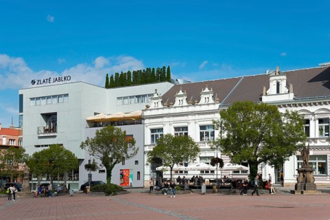 Modern and historical building on a busy square on a sunny day, Houses on Peace Square, Namesti