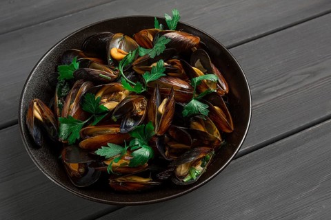 Fresh, Boiled mussels, Black Sea, with parsley and lemon, on a wooden table, no people
