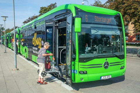 Elderly woman boards an electric bus in Ystad, Skåne County, Sweden, Scandinavia, Europe