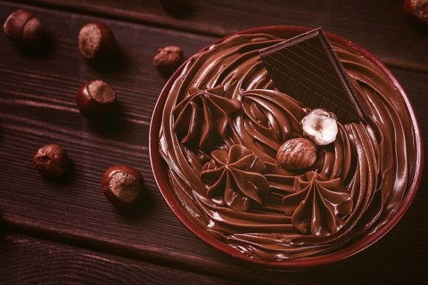 Chocolate nut paste, mousse, pasta, in a cup, on a wooden table, top view, selective focus, no