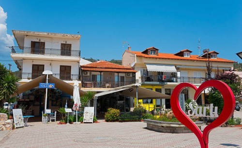A lively town square with buildings and a large red heart in the centre, Sarti, Sithonia,