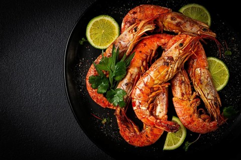 Langoustines, Australian, freshly frozen on ice, top view, lime and greens