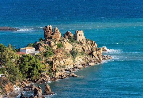 Ruins of Torre Caldura Castle on a rocky promontory jutting into the sea near Cefalu, Sicily,