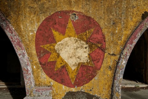 A ruined wall with a faded red and yellow star symbol on it, Italian Governor's Palace, Ruins,