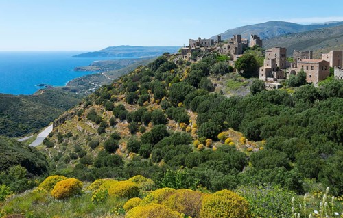 Historic stone houses of a village overlooking the coast under a clear sky, residential towers,