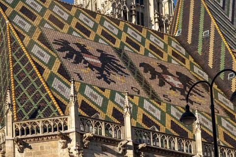 Coat of arms made of roof tiles on the roof of St Stephen's Cathedral in Vienna, Austria, Europe