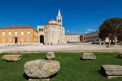 Architectural remnants on display at Roman forum ruins with the church of Saint Donatus and Bell