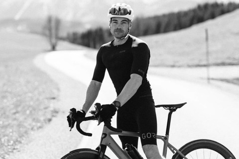 Road bike rider in spring near Halblech in the Allgäu in front of a picturesque backdrop of the