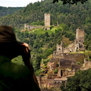 A man photographs the two castles, Oberburg and Niederburg of Manderscheid, South Eifel, Eifel,