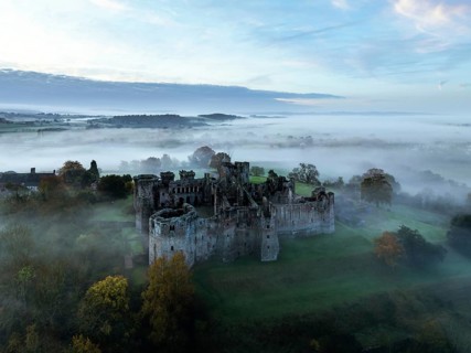 Raglan Castle in the fog at dawn from a drone, Monmouthshire, Wales, England, United Kingdom,