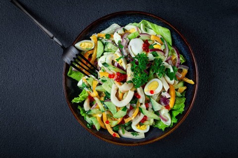 Salad with squid, fresh cucumber, eggs, sweet pepper, red onion, with dressing, homemade, no people