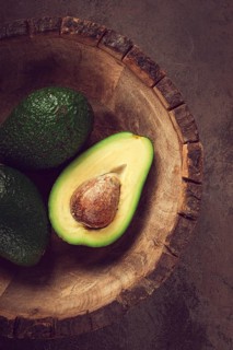 Fresh, sliced avocado, in a wooden plate, top view, food background, concept, food styling