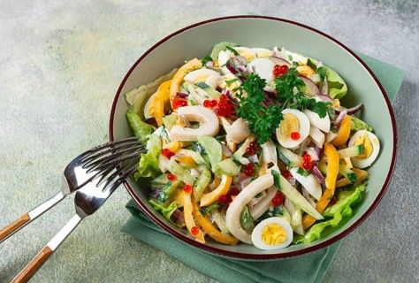 Salad with squid, fresh cucumber, eggs, sweet pepper, red onion, with dressing, homemade, no people