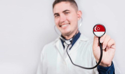 Smiling doctor showing stethoscope with Singapore flag. Singapore National Healthcare concept