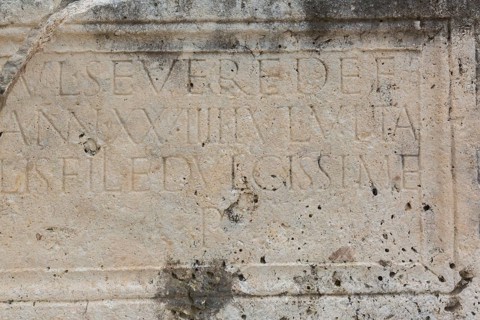 Close-up of carved letters on old slab of limestone at ancient 3rd century Roman ruins of Salona