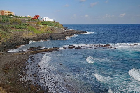 The coastline with gentle waves, houses and rocky surroundings, San Andres, La Palma, Canary