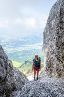 Female mountaineer with helmet climbing a rock face, ascent to the Ackerlspitze, Wilder Kaiser,