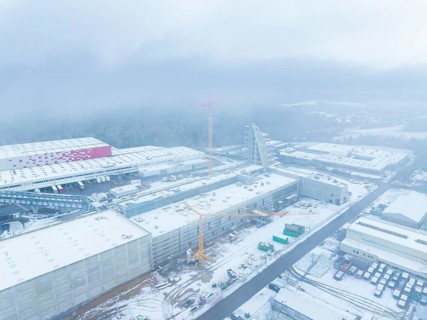 Snow-covered industrial area with crane and construction site in foggy surroundings, Häfele,