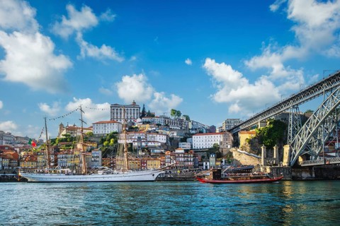 View of Porto city and Douro river with traditional boats with port wine barrels and sailing ship