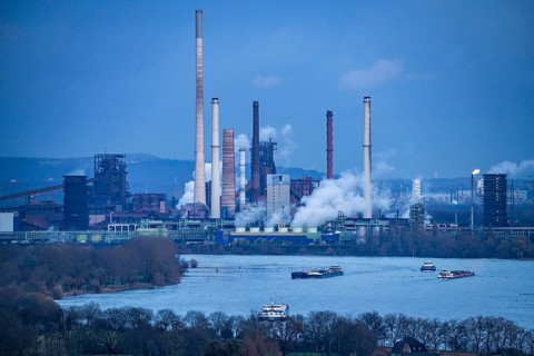 Industrial backdrop of the ThyssenKrupp Steel steelworks in Duisburg-Bruckhausen, cargo ships on
