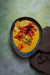 Pumpkin cream soup, curry, fried bacon, bruschetta chips, micro-greens, top view, no people