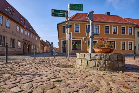 Historic public hand pump, signpost to the museum and Marienstern Monastery, Mühlberg Elbe,