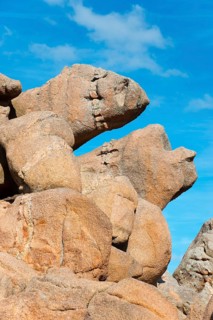 Large, eroded rock formations under a blue sky are reminiscent of faces, Ploumanac'h, Ploumanach,