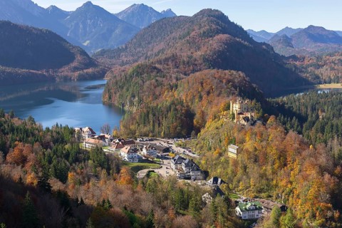 Idyllic valley with autumn-coloured forest, enchanting mountains and a tranquil lake, Schwansee,