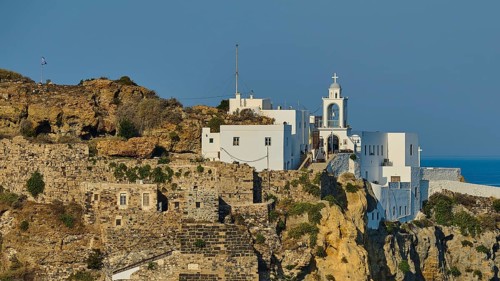 White church and building on a cliff overlooking the Mediterranean Sea on a sunny day, morning