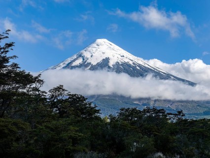 Clouds and forests on the snow-covered Osorno volcano, Chile, South America