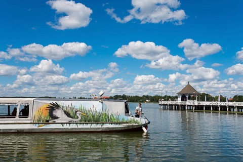 A boat on a lake with a pier and pavilion under a blue sky, Drawenzsee, Jezioro Drweckie, Ostroda,