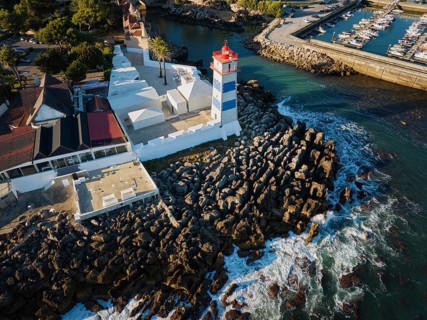 Aerial view of Santa Marta lighthouse and Cascais marina with moored yacht boats with Cascais