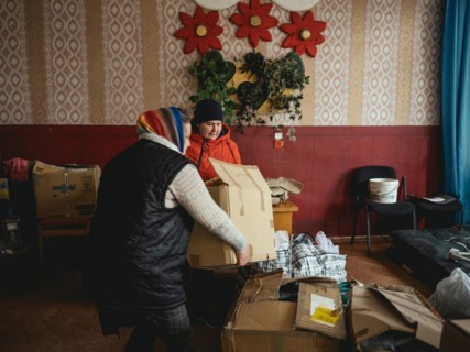 Two woman unload a delivery of relief supplies from the NGO Unbreakable Kharkiv at the village