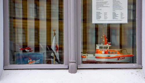 Window of a residential building in the city harbour of Stralsund, model of the rescue boat Hertha
