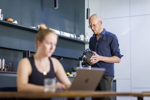 Symbolic photo on the subject of division of labour for couples in the household. A woman sits at a