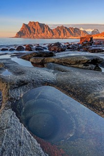 Rocky coast in front of steep mountains in the evening light, winter, the eye, Utakleiv, Vestoya,