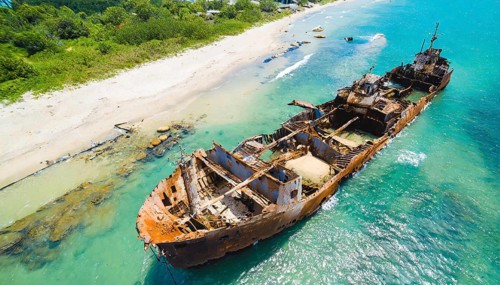 A dilapidated, rusty shipwreck in clear turquoise water on a sunny day, symbol photo, AI generated,