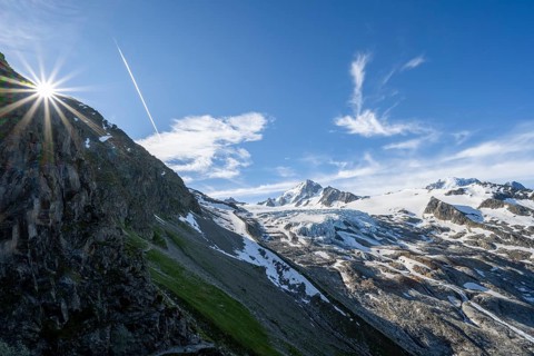High alpine mountain landscape with sun star, summit of Aiguille de Chardonnet and Glacier du Tour,