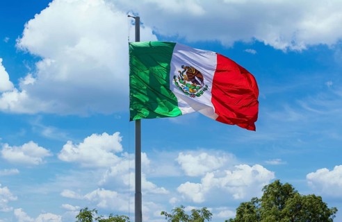 Los Cabos, Mexico, Mexican tricolor national striped flag proudly waving at mast in the air with