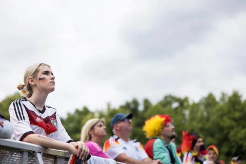 A woman watches the football match in the fan zone at the Brandenburg Tor during the quarter-final