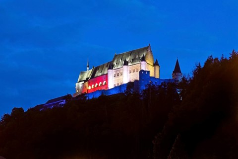 Vianden Castle, hilltop castle illuminated in the colours of the Luxembourg flag for the bank