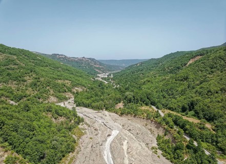 Only a trickle of water flows through the largely dry bed of the Torrente Nocito stream. Aerial
