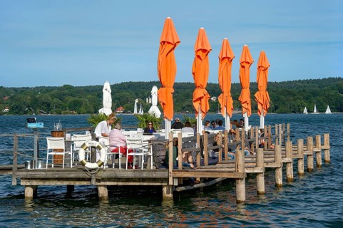 Old jetties with dining tables, lakeside restaurant, former Undosa wave pool, now H'ugo's Beach