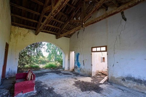 Abandoned building with cracks in the walls and a dilapidated interior. A passageway surrounded by