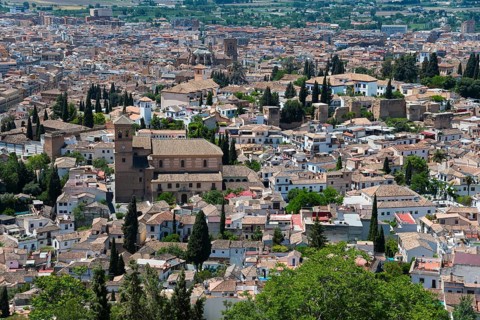 View over a historic town with brick houses, green vegetation and a peaceful Mediterranean