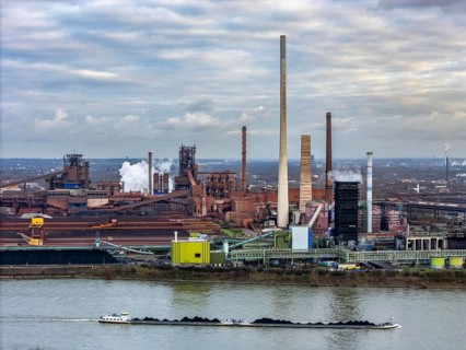 Industrial backdrop of the ThyssenKrupp Steel steelworks in Duisburg-Bruckhausen, cargo ship, coal