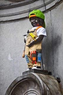 Bronze statue Manneken Pis by Jérôme Duquesnoy, fountain figure of a urinating boy in costume,