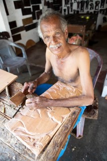 Sri Lankan man with bare upper body carving a wooden picture, Kandy, Central Province, Sri Lanka,