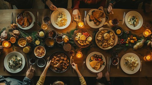 Directly overhead family and friends enjoy A delicious variety of holiday food at the table.