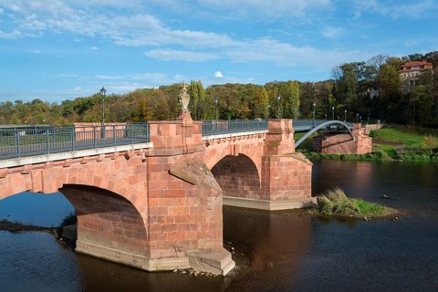Historic stone bridge over a river with clear sky and autumn vegetation, Pöppelmannbrücke, River